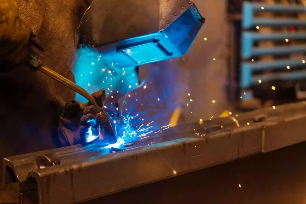 Gros plan sur la torche MIG générant un bain de fusion et des étincelles