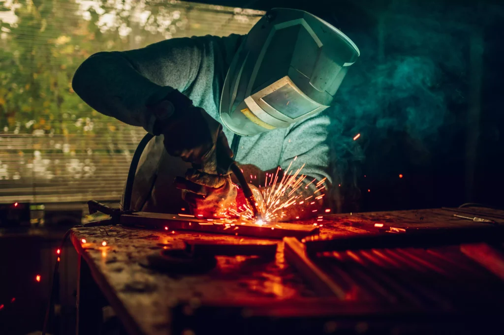 soudeur MIG réalisant une soudure avec projections dans un atelier