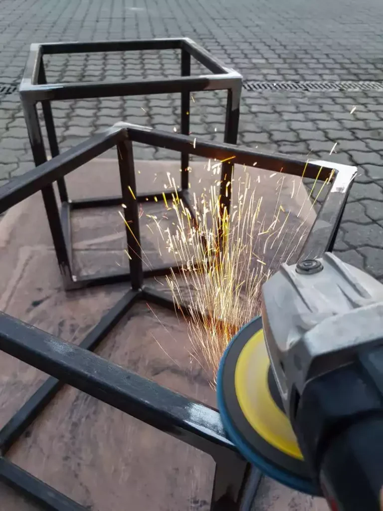 Gros plan sur un meulage d’angle de structure métallique avec disqueuse et étincelles.